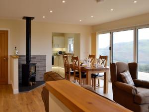 a kitchen and living room with a table and a fireplace at Sweet Meadow Lodge in Llandrindod Wells