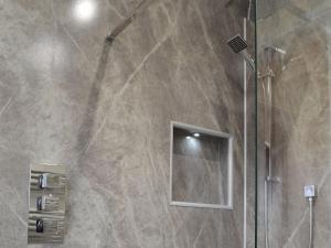 a bathroom with a shower with a glass door at Sweet Meadow Lodge in Llandrindod Wells