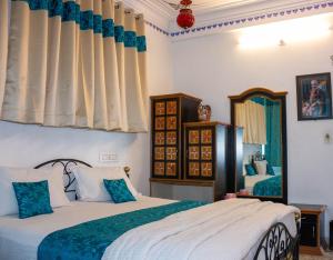 a bedroom with two beds and a mirror at Baba Palace - A Heritage Hotel, Udaipur in Udaipur