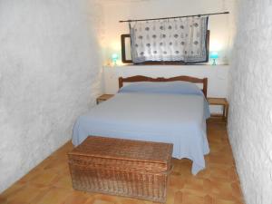 a bedroom with a bed and a wicker table at Cotetonda - Appartamento Ilvia in Marciana Marina