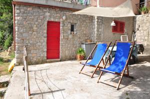 twee blauwe stoelen voor een gebouw bij Cotetonda - Appartamento Ilvia in Marciana Marina