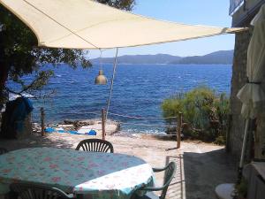 a table with an umbrella and a view of the water at Cotetonda - Appartamento Ilvia in Marciana Marina