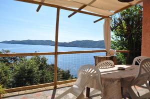 een tafel en stoelen op een veranda met uitzicht op het water bij Cotetonda - Appartamento Taccola in Marciana Marina