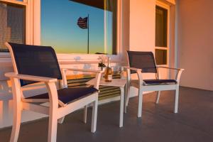 Duas cadeiras e uma mesa num alpendre em Atlantis Oceanfront Inn Gloucester em Gloucester