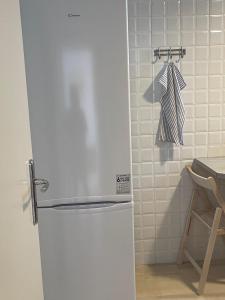 einen weißen Kühlschrank in einer Küche neben einem Tisch in der Unterkunft Sunrise pearl in Attika Riviera apt and Parking in Rafina