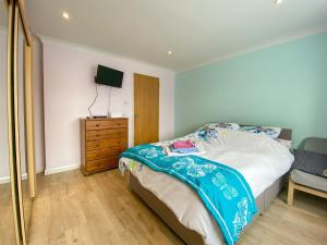 a bedroom with a bed and a dresser and a television at The Annexe At Whitfield in Saint Margaretʼs at Cliffe