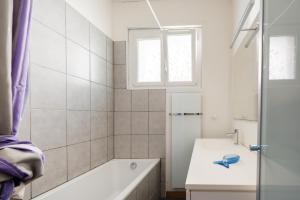 a bathroom with a tub and a sink and a window at La Castine in Saint-Cast-le-Guildo