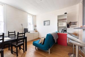 a living room with a dining room table and a kitchen at La Castine in Saint-Cast-le-Guildo