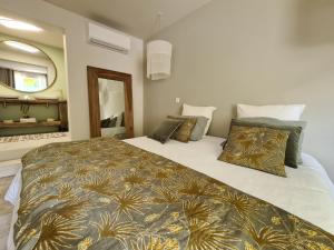 a bedroom with two beds and a mirror at La Maison de Lyna in Aigues-Mortes