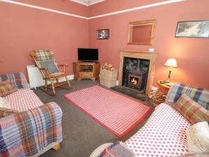 a living room with two couches and a fireplace at Bod Gwynedd in Betws-y-coed
