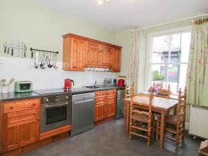 a kitchen with wooden cabinets and a table in it at Bod Gwynedd in Betws-y-coed