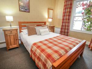 a bedroom with a large bed and a window at Bod Gwynedd in Betws-y-coed