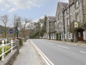 una strada vuota in una città con un edificio in pietra di Bod Gwynedd a Betws-y-coed