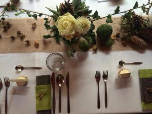 une table avec des fourchettes, des cuillères et des fleurs. dans l'établissement Hotel Zlaty Jelen, à Horažďovice