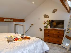 a bedroom with a bed with a tray of food on it at Ty Bobbet in Amlwch