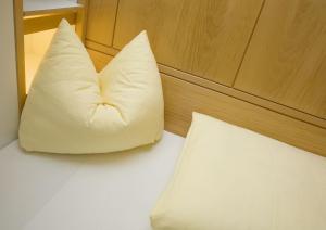 a white pillow sitting on top of a bed at Kolpinghaus Innsbruck in Innsbruck