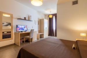 una camera d'albergo con letto e scrivania con computer di Hotel Torre Del Sud a Modica