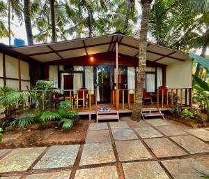 a house with a porch with chairs and a patio at Jardim a Mar in Agonda