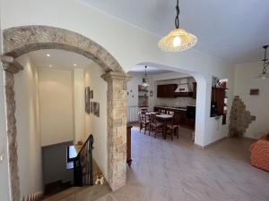 ein Wohnzimmer mit einem Torbogen und einem Esszimmer in der Unterkunft Calacta casa mia in Caronia