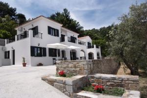 Casa blanca grande con pared de piedra en Eri Rooms to Let, en Raches