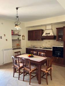 a kitchen with a wooden table with chairs and a kitchenanism at Calacta casa mia in Caronia