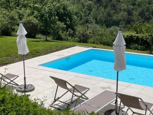 einen Pool mit Stühlen und Sonnenschirmen neben einem Pool in der Unterkunft Cinque Terre, Tuscany, Liguria, Lerici #5 in Lerici