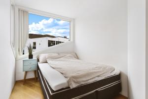 a small bedroom with a bed and a window at The View in Tromsø