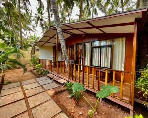 a small house with a porch in front of it at Jardim a Mar in Agonda