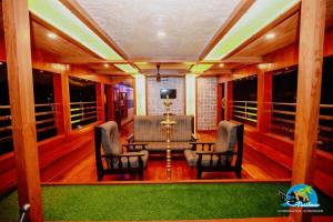 a living room with a pool table and two chairs at Vaishnav Tours in Alleppey