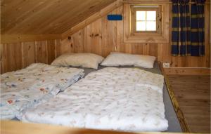 2 camas en una cabaña de madera con ventana en Stallen 2, en Rauland