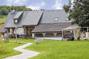 una casa con techo de gambrel y un patio de césped en Domaine de la Chaux de Revel, en Saint-Martin-Valmeroux