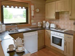 a kitchen with a sink and a stove top oven at The Retreat in Woolfardisworthy