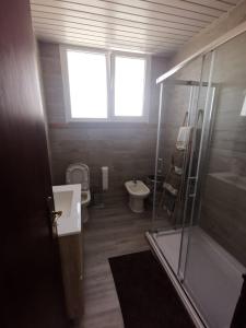 a bathroom with a toilet and a sink and a shower at Casas Zé Pinto in Hospital
