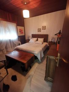 a bedroom with a large bed and a table at Casas Zé Pinto in Hospital