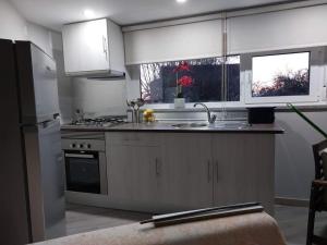 a kitchen with white cabinets and a sink and a refrigerator at Casas Zé Pinto in Hospital