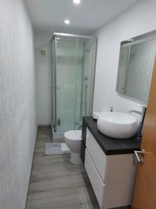 a bathroom with a sink and a toilet and a shower at Casas Zé Pinto in Hospital