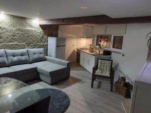 a living room with a couch and a kitchen at Casas Zé Pinto in Hospital