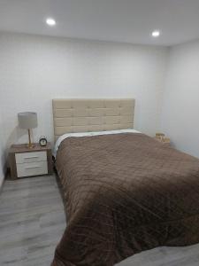a bedroom with a bed and a night stand with a lamp at Casas Zé Pinto in Hospital