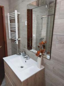 a bathroom with a white sink and a mirror at Casas Zé Pinto in Hospital