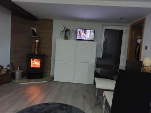 a living room with a fireplace and a tv on a wall at Casas Zé Pinto in Hospital