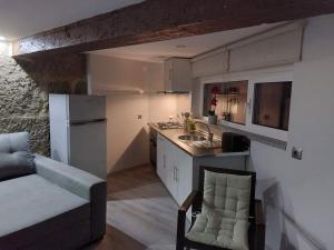 a kitchen with a couch and a sink and a refrigerator at Casas Zé Pinto in Hospital