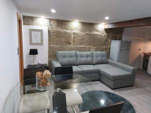a living room with a couch and a glass table at Casas Zé Pinto in Hospital