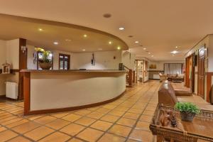 a large lobby with a bar in a building at Esquilo Hotel in Monte Verde