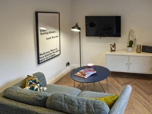 a living room with a couch and a table at Dove Cottage in Knaresborough