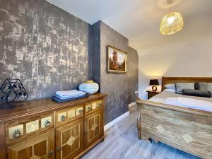 um quarto com uma cama e uma cómoda em madeira em Station Suite 1 - Uk40737 em North Tidworth