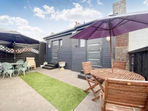 a patio with a table and a purple umbrella at Station Suite 1 - Uk40737 in North Tidworth