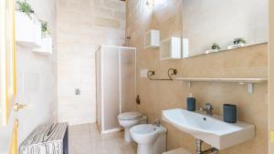 ACAMYA LUXE Apartment في أكايا: حمام مع حوض أبيض ومرحاض