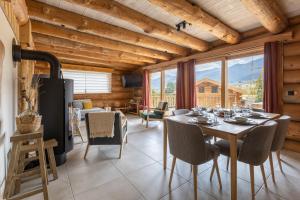 a dining room with a table and chairs and a large window at Chalet L'Axurit - Familial Jacuzzi Sauna in La Cabanasse