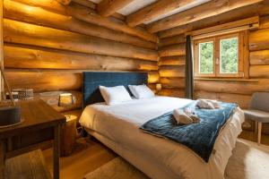 sypialnia z łóżkiem w drewnianym domku w obiekcie Chalet L'Axurit - Familial Jacuzzi Sauna w mieście La Cabanasse