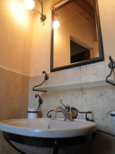 a bathroom sink with a mirror on the wall at B&B Piazza del Papa in SantʼAngelo in Vado